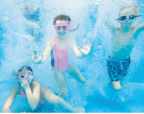 little kids swimming  in pool  underwater 