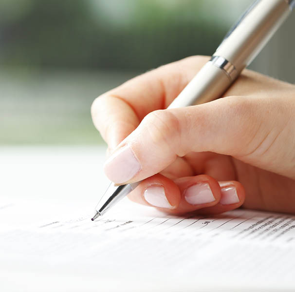 Businesswoman s hand with pen completing personal information on a form