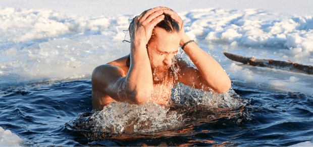 young, slim, handsome, sporty man with a red beard and long hair, naked, diving into ice-cold water in winter, against a snowy landscape, Ukraine, Shostka