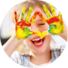 happy funny child girl draws laughing shows hands dirty with paint 