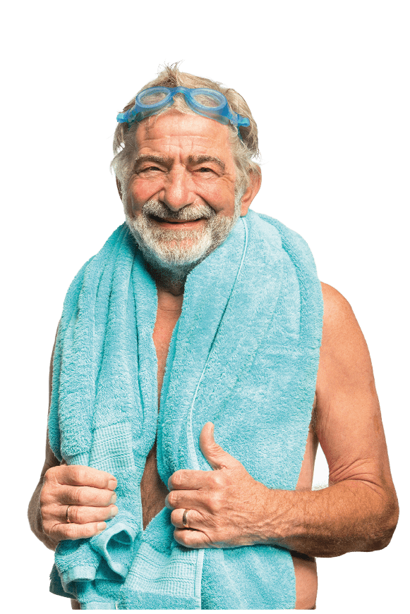 A happy mature man smiles at the camera as he gets ready t go swimming  He has a towel around his neck and swimming goggles on his head 