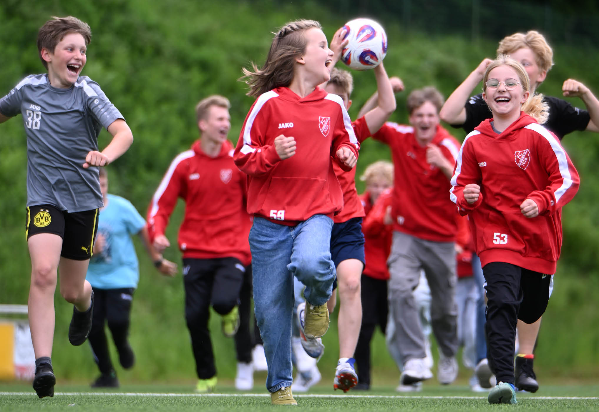 Headerbild mit unbeschwert rennenden, lachenden Kindern eines Sportvereins. M glich durch ein Schutzkonzept