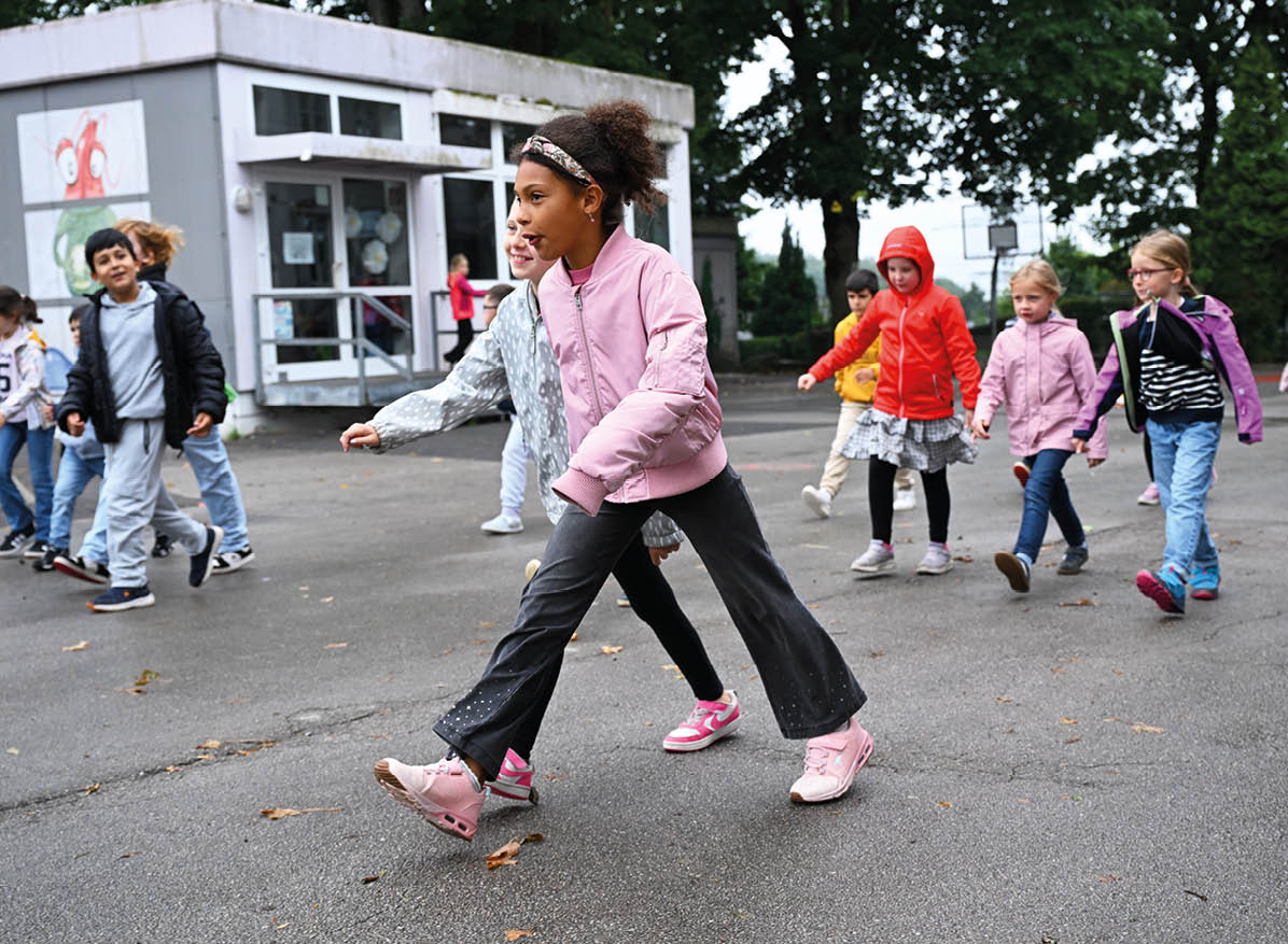 Kinder laufen und spielen auf dem Pausenhof in der Offenen Ganztagsschule des RSV vo