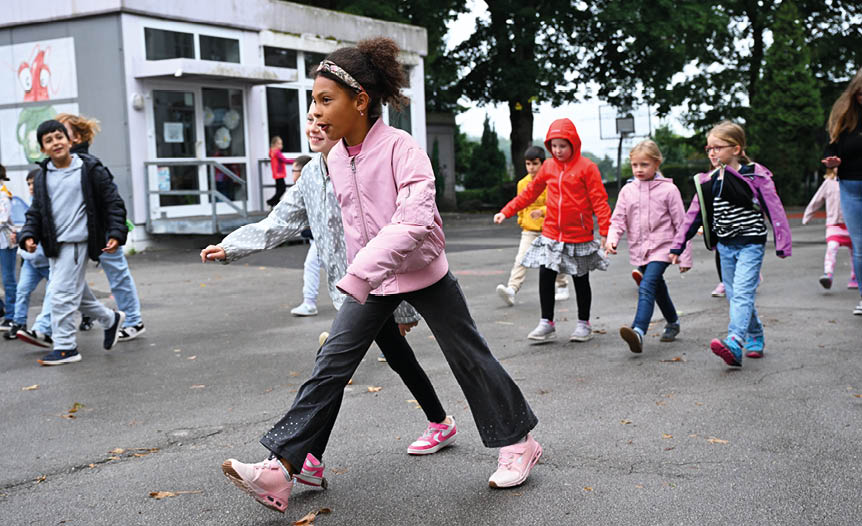 Kinder laufen und spielen auf dem Pausenhof in der Offenen Ganztagsschule des RSV vo