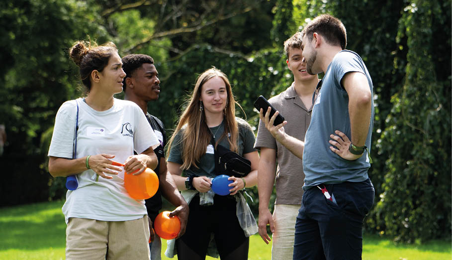 Mehrere engagierte Sporthelfer auf einer Wiese stehend