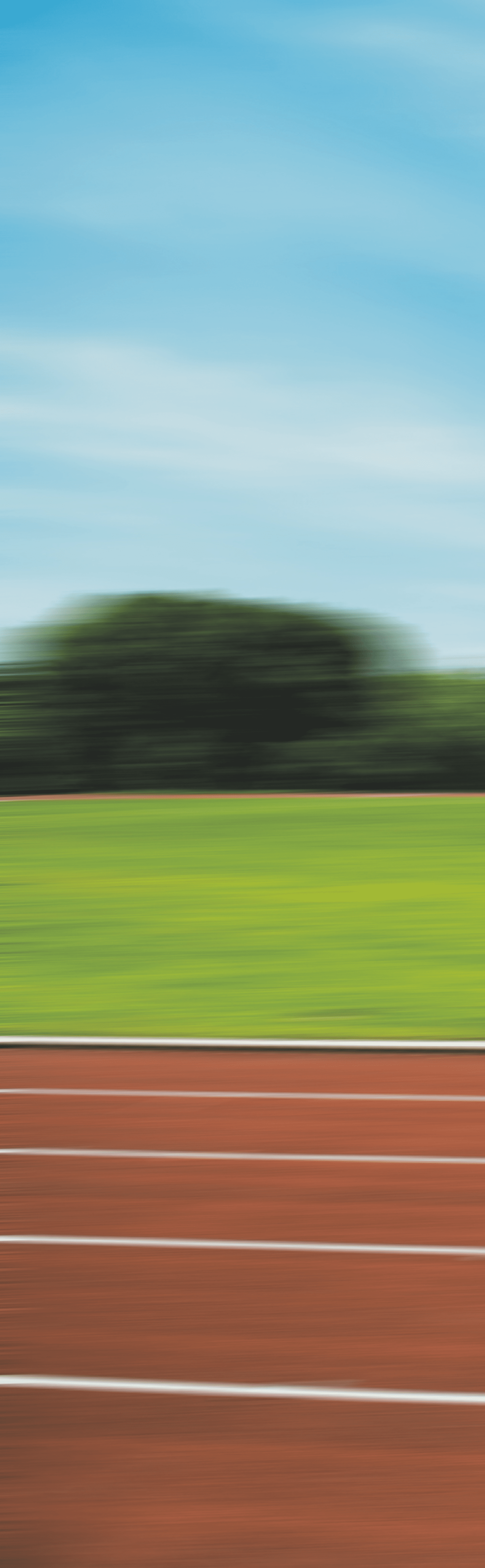 Hintergrundbild. Ausschnitt eines gr nen Rasen-Spielfeldes mit Tartanbahn