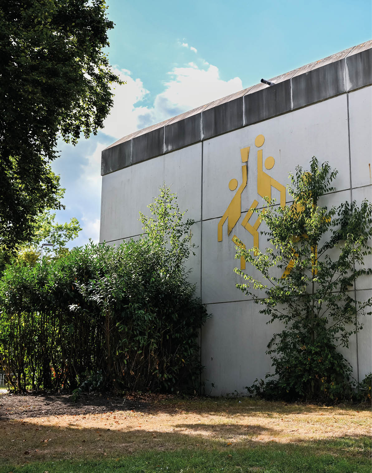 Au enwand der Turnhalle Stromberg mit markantem Baksetball Olympia Piktogram von Otl Eicher auf der Fassade