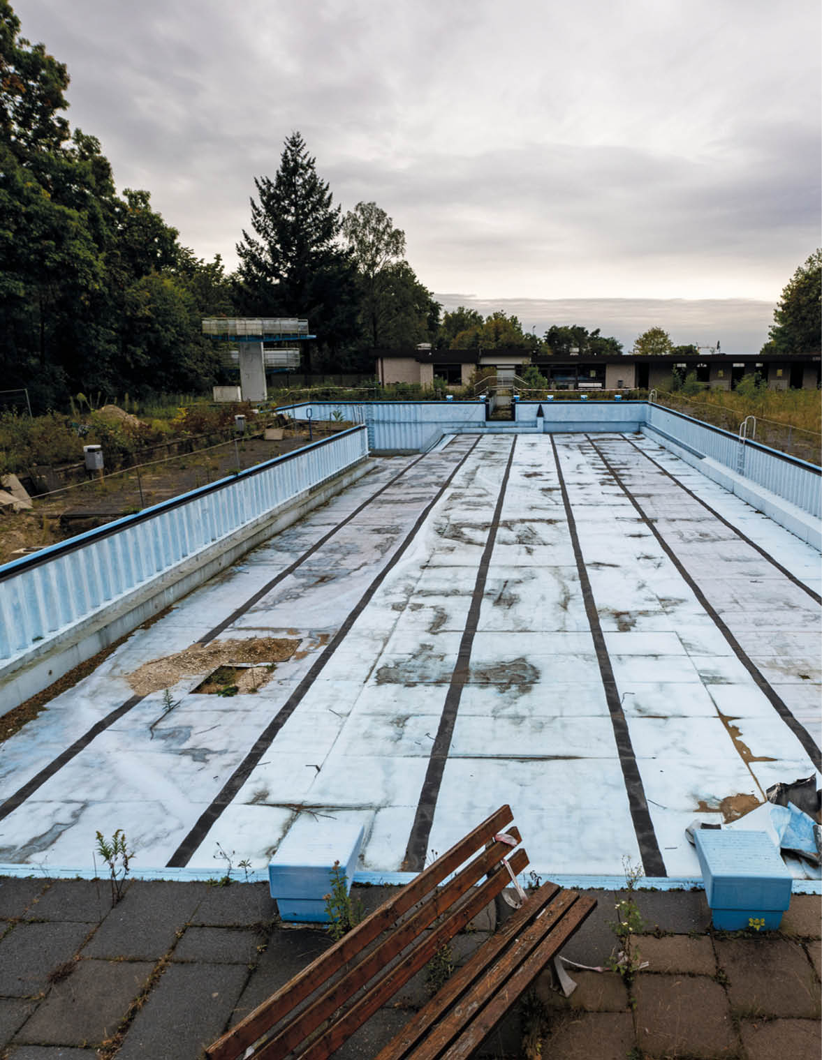 Foto des leeren Becken des Freibads lippischen Oerlinghausen. Zu sehen ist der langsame Verfall der Sportanlage