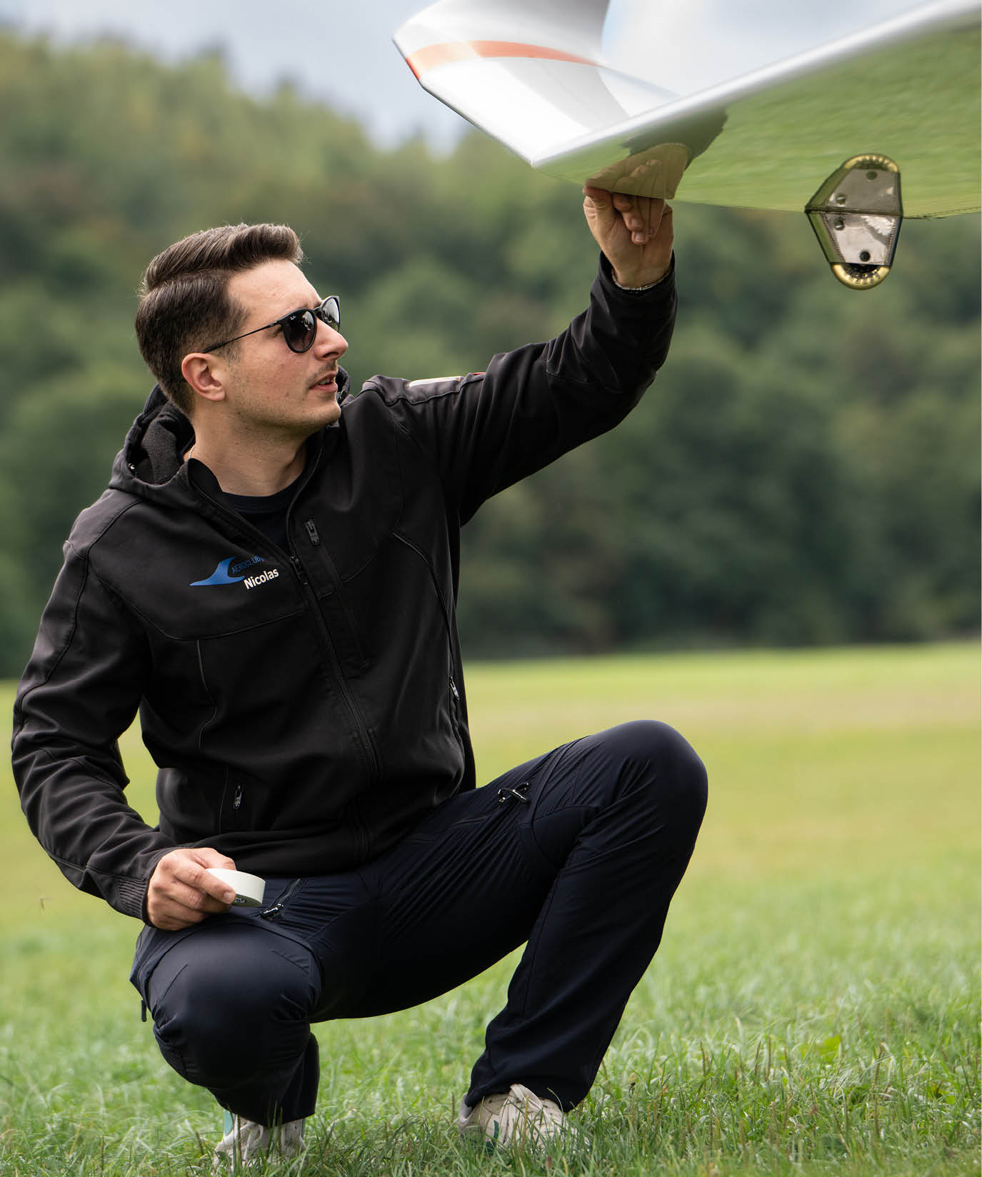 Nicolas Kierdorf das Toptalente NRW im Herbst kniet auf der Startbahnwiese und inspiziert sein Segelflugzeug