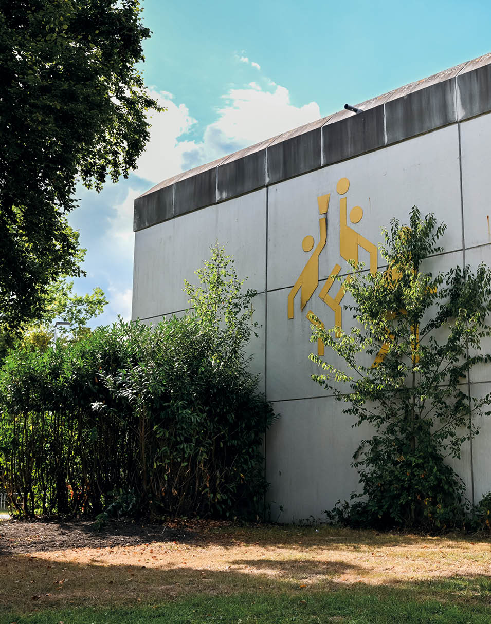 Au enwand der Turnhalle Stromberg mit markantem Baksetball Olympia Piktogram von Otl Eicher auf der Fassade