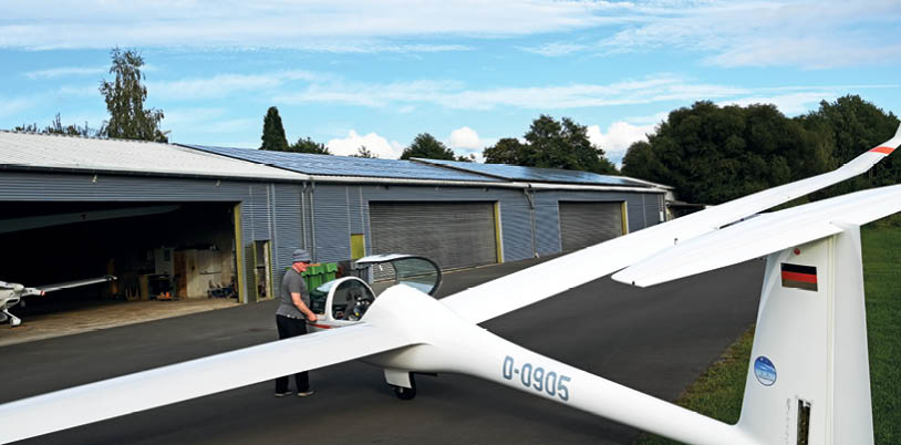 Sportflugpaltz des LSV Wipperf rth. Im Vordergrund ein Segelflugzeug im Hintergrund die Halle mit dem neuen Solardach