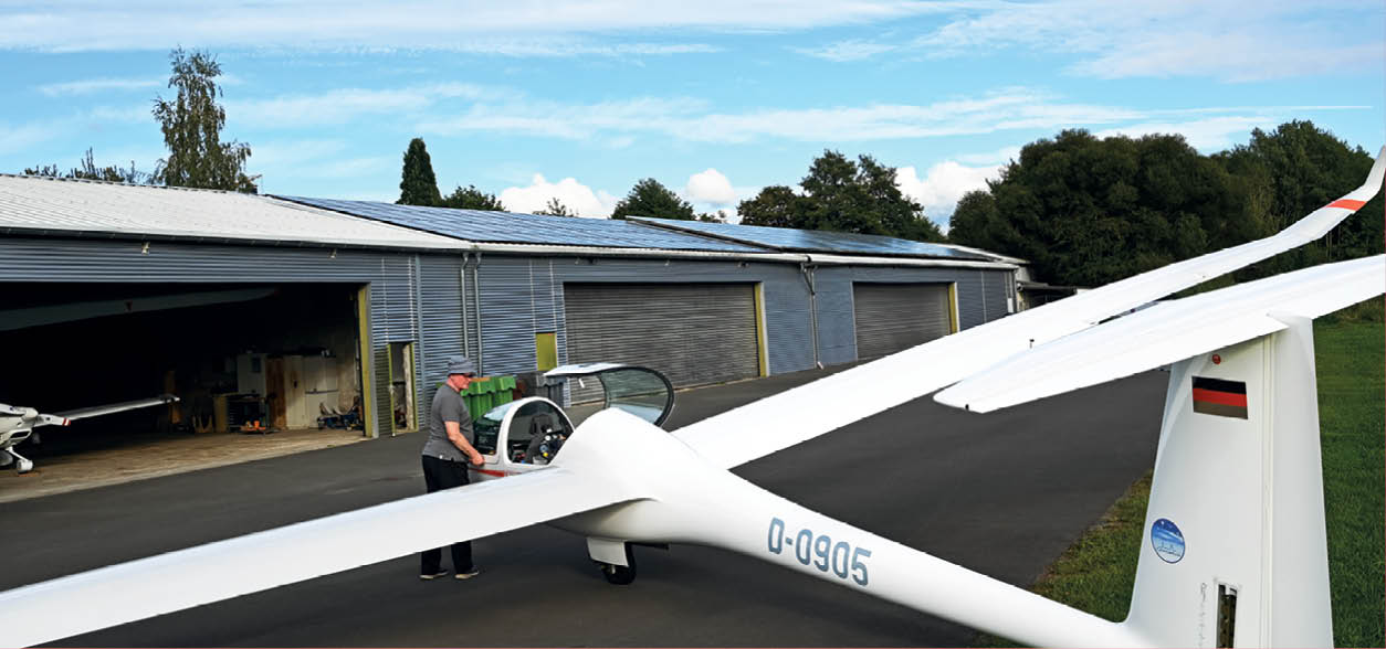 Sportflugpaltz des LSV Wipperf rth. Im Vordergrund ein Segelflugzeug im Hintergrund die Halle mit dem neuen Solardach
