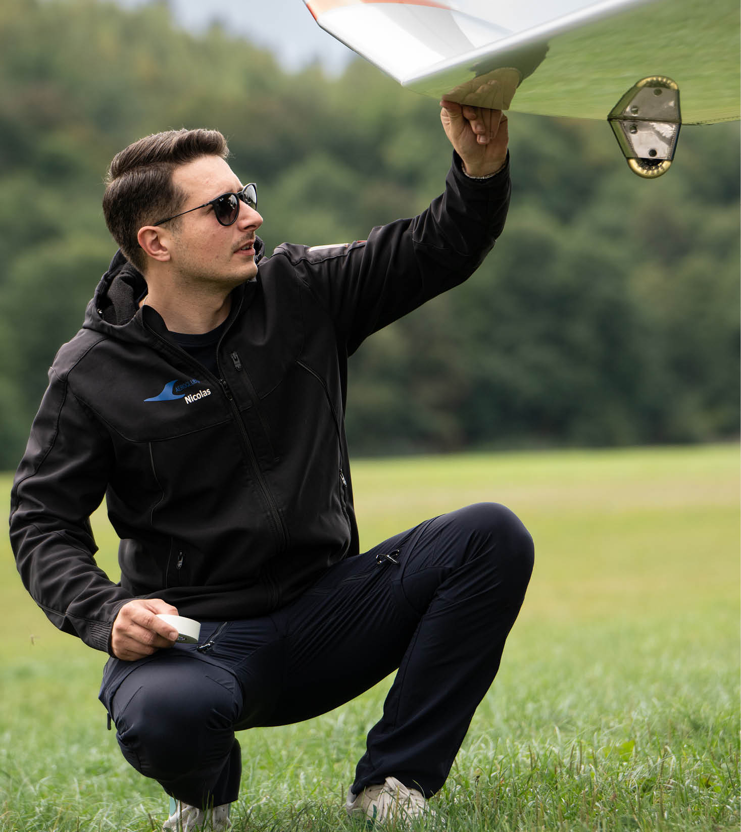 Nicolas Kierdorf das Toptalente NRW im Herbst kniet auf der Startbahnwiese und inspiziert sein Segelflugzeug