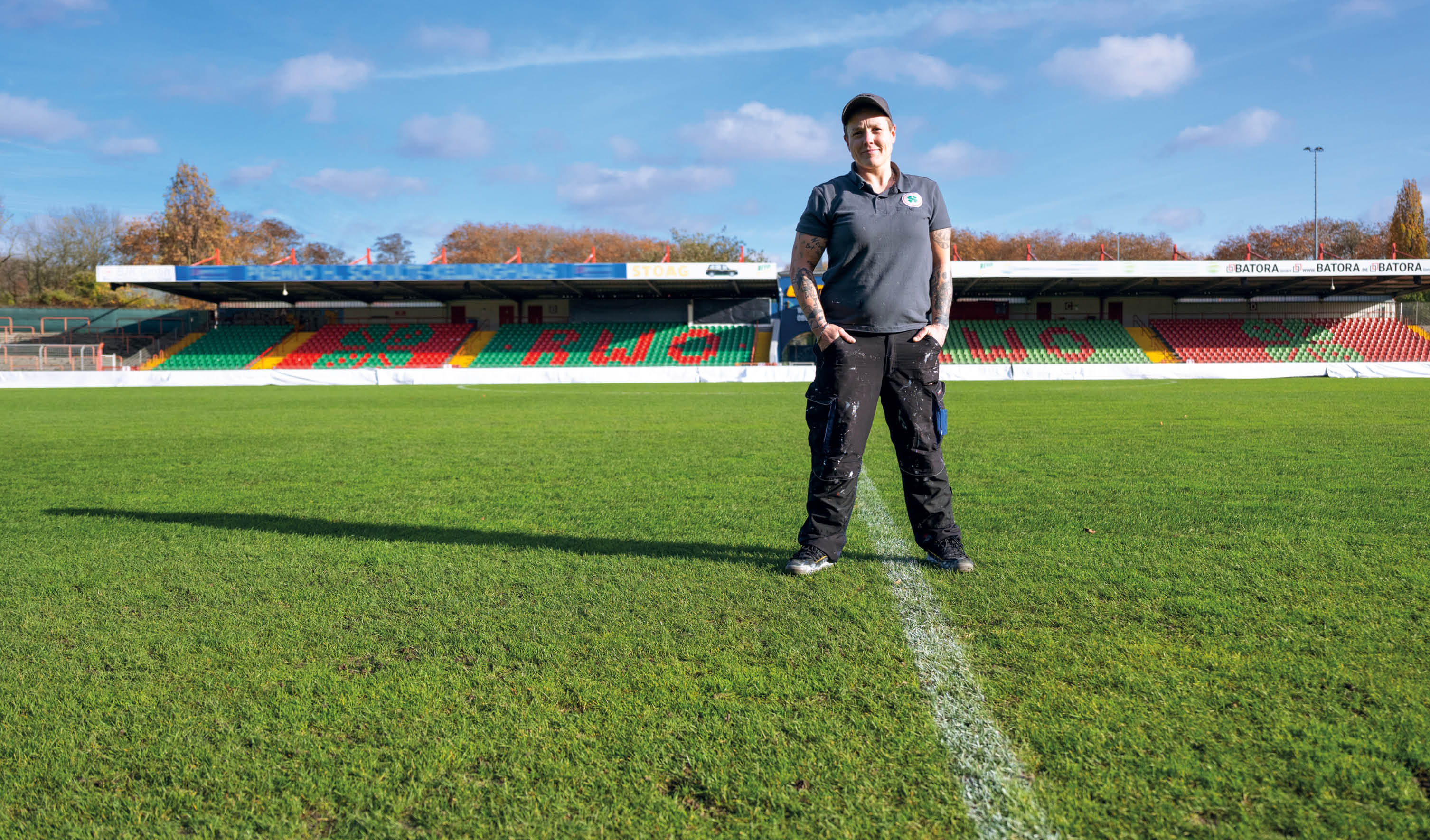 Platzwartin stehend auf einem Stadionplatz 