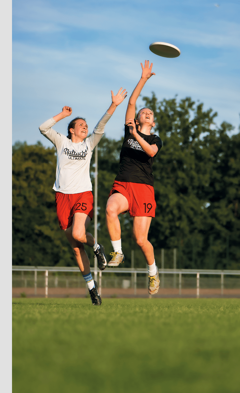 Discogolf - Zwei Frauen springen hoch und versuchen die Frisbee zu fangen