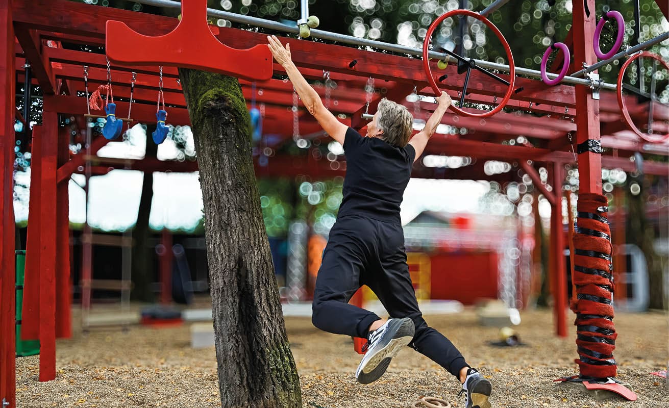 Ninja Sport. Eine Frau h ngelt sich einem Hinderniss enttlang