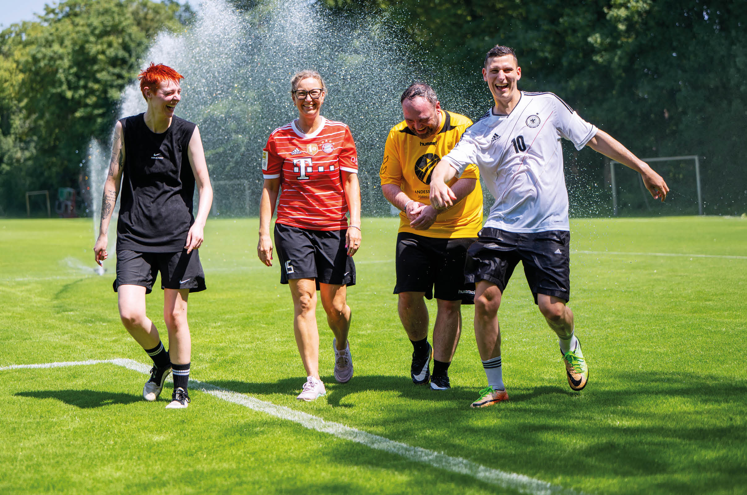 Bild einer leeren Sporthalle. Zu sehen ist der rote Hallenboden mit den markiereungen f r verschiedene Spielfeder. Eine  braune Holzwand im Hintergrund und im rechten Bereich eine Fensterfront.