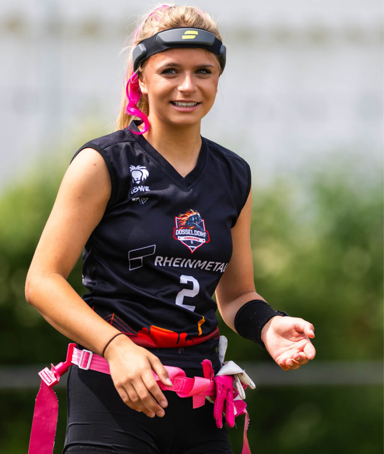 Nika Wiesner mit Stirnband tr gt einen G rtel mit Flaggen und steht auf einem Spielfeld im Freien bereit zum Flag-Football