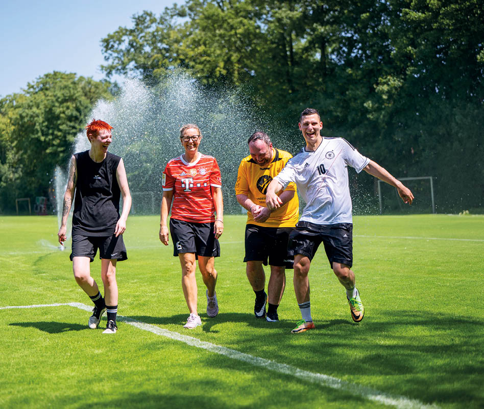 Bild einer leeren Sporthalle. Zu sehen ist der rote Hallenboden mit den markiereungen f r verschiedene Spielfeder. Eine  braune Holzwand im Hintergrund und im rechten Bereich eine Fensterfront.