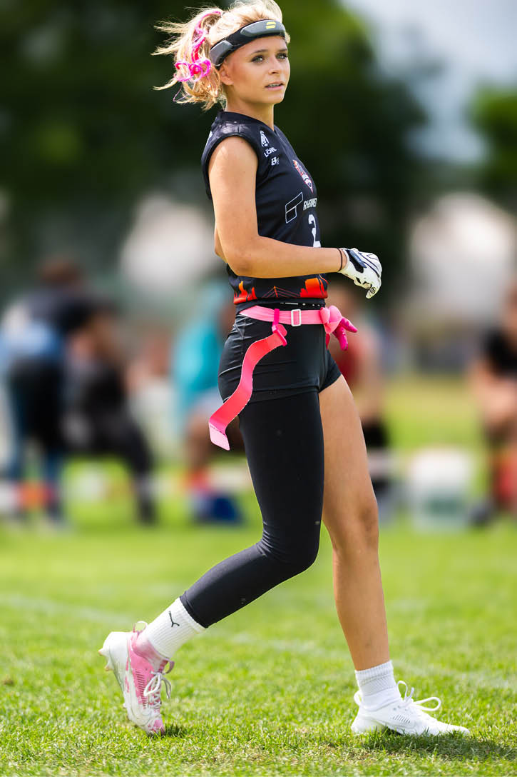Eine Person mit Sportkleidung und pinken B ndern spielt auf einem gr nen Spielfeld bei Tageslicht. Beschreibung von KI generiert