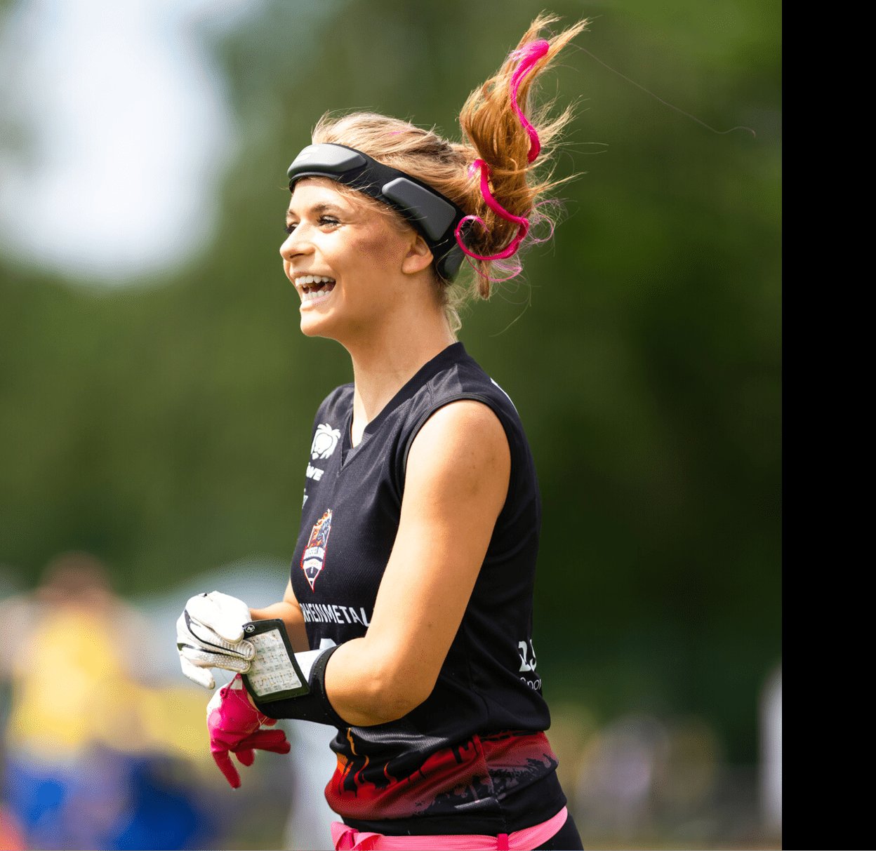 Nika Wiesner, WestLotto TopTalent mit hochgebundenem Haar und pinken Haarstr hnen tr gt sportliche Kleidung und Handschuhe und h lt ein Notizbuch in der Hand.   