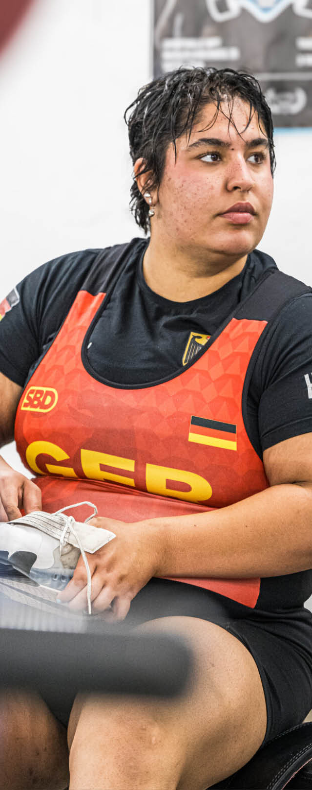 Eine Person mit Helm und Sportbekleidung sitzt auf einem Paddleboard auf einem Gew sser und h lt ein Paddel.   Beschreibung von KI generiert